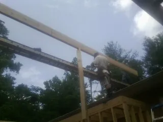 Carpenter setting a ridge beam over a new addition frame — Ice Dam Removal by Roofing Brothers in Cascade
